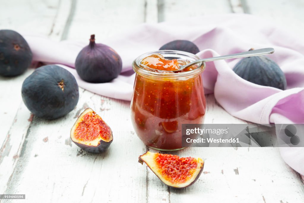 Organic figs and a glass of fig jam on a wood