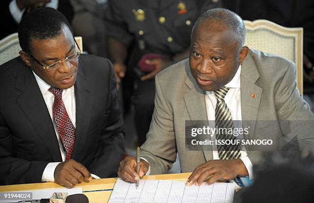 Ivory Coast President Laurent Gbagbo and the chairman of his party Popular Front party Pascal Affi N'Guessan sign a document after he submitted on...