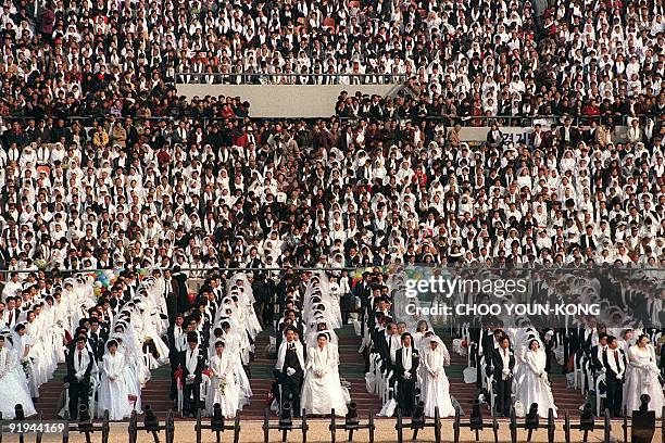 Unification Church members, known as "Moonies," get married in a mass wedding ceremony at Seoul's Olympic stadium 07 February. Unification Church...