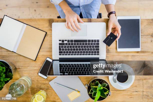 top view of woman at wooden desk with credit card and laptop - mobile order stock pictures, royalty-free photos & images