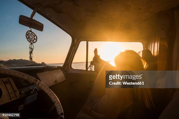spain, tenerife, young woman lying in a van at sunset - goldene stunde stock-fotos und bilder