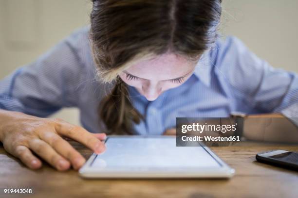 close-up of woman bending over tablet at desk - myopia stock pictures, royalty-free photos & images