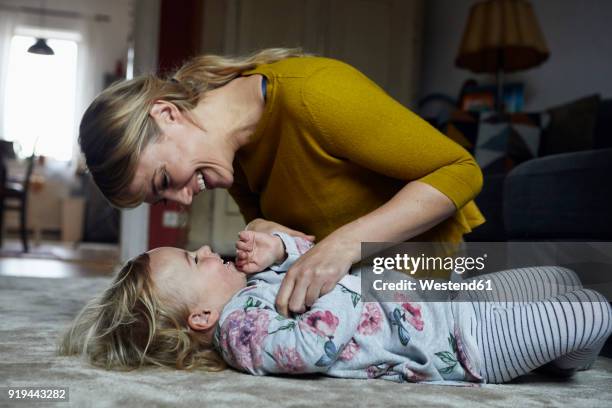 mother and little daughter having fun together at home - tickling 個照片及圖片檔