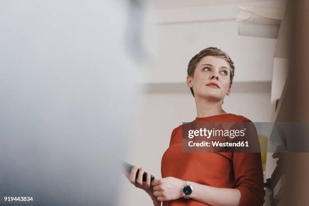 portrait of woman holding cell phone - froschperspektive stock-fotos und bilder