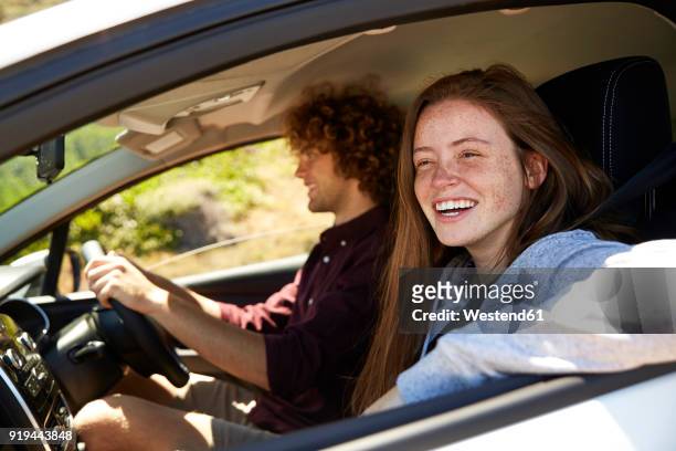 young couple in car - freie fahrt stock-fotos und bilder