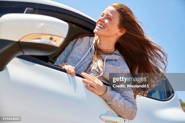 young woman leaning out of window of a car - one kid one world a night of 18 laughs stockfoto's en -beelden
