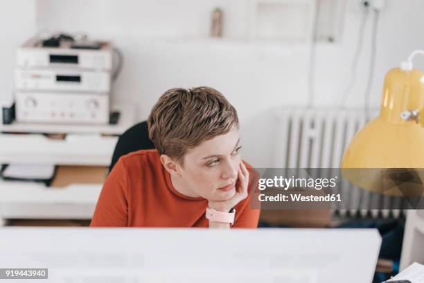 woman at desk in office thinking - distrarsi foto e immagini stock