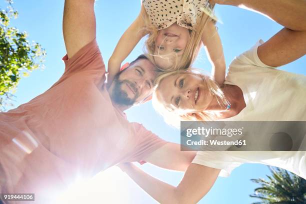 portrait of happy family huddling under blue sky - joined at hip stock pictures, royalty-free photos & images
