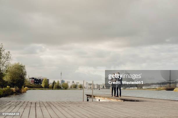 two businessmen standing on jetty at a lake talking - distance stock pictures, royalty-free photos & images