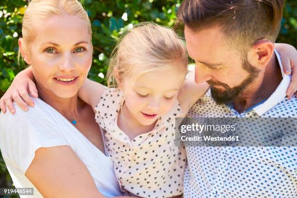 portrait of happy girl between her parents - femme entre deux hommes photos et images de collection