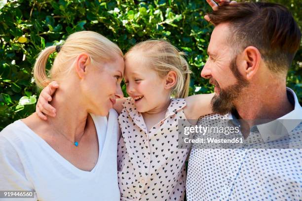 portrait of happy girl between her parents - femme entre deux hommes photos et images de collection