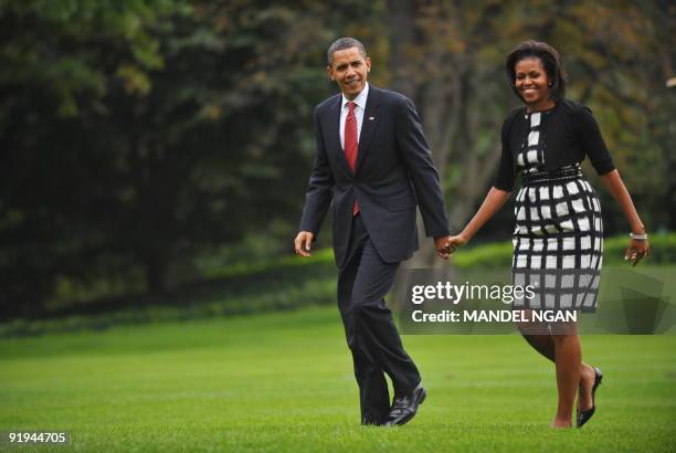 President Barack Obama and First Lady Michelle Obama make their way from Marine One October 2, 2009 upon return to the White House in Washington, DC....