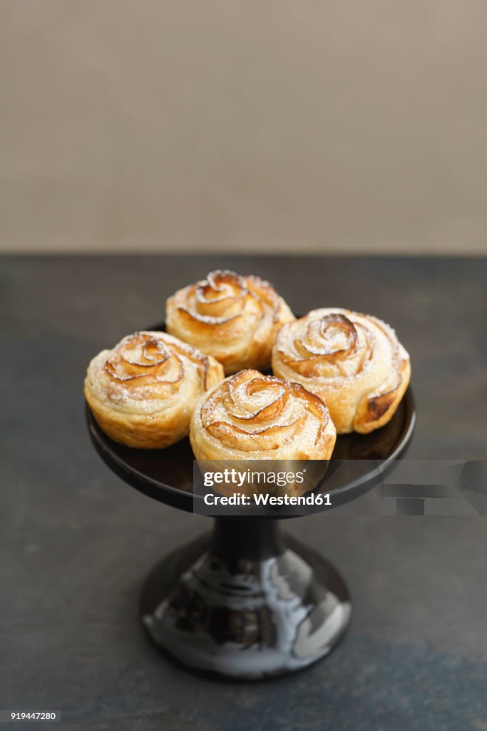Home-baked small apple tart with rose pattern on cake stand