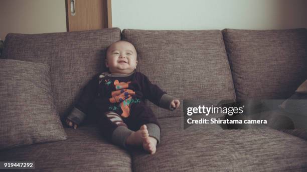 baby is sitting on the sofa - shiratama camera stock pictures, royalty-free photos & images