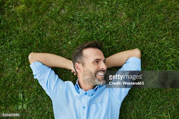 man relaxing on a meadow, top view - lying down stockfoto's en -beelden