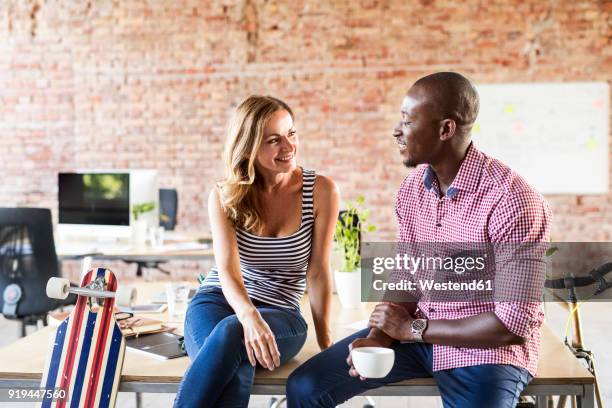 smiling casual colleagues in office - work romance stock pictures, royalty-free photos & images