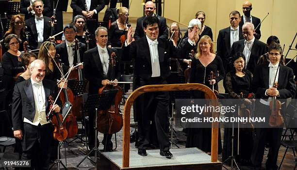 Music director Alan Gilbert of the New York Philharmonic gestures to thank spectators who keep applauding at the end of a concert given at the Hanoi...