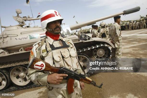 An Iraqi Military Police officer stands next to a refurbished Russian made T-55 tank on display during training operations at a desert range some 40...