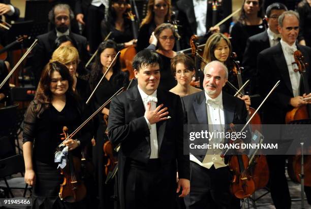 Music director Alan Gilbert of the New York Philharmonic gestures to thank spectators at the end of a concert given at the Hanoi Opera House on...
