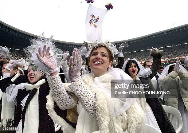 "Moonie" brides and bridegrooms from Albania celebrate at the end of a mass wedding ceremony at Chamsil Olympic Stadium in Seoul 13 February 2000...