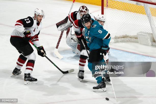 Joe Pavelski of the San Jose Sharks goes for the puck while being defended by Oliver Ekman-Larsson, Scott Wedgewood and Freddie Hamilton of the...