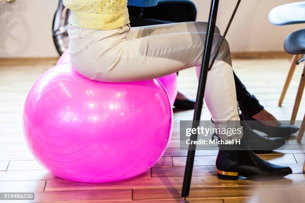 business women sitting on fitness ball - beige trousers stock pictures, royalty-free photos & images