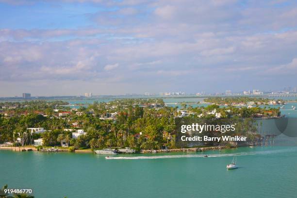 view from high up of boats moving through biscayne bay near star island - biscayne island stock pictures, royalty-free photos & images