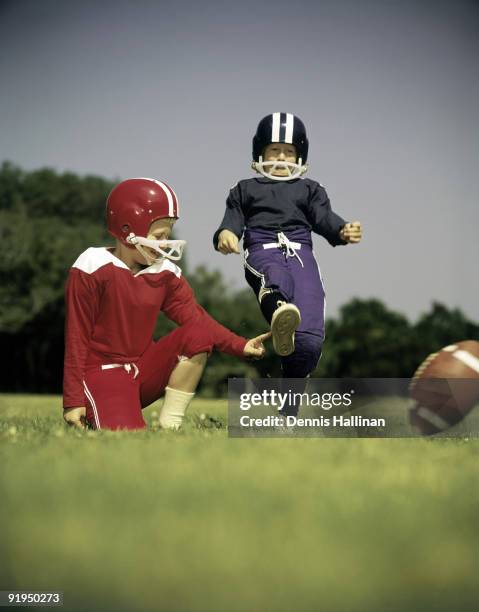 Two small boys playing football in backyard