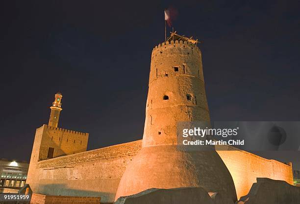 the towers of the al fahidi fort which houses the dubai museum, illumunated at night - al fahidi fort stock-fotos und bilder