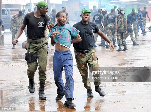 Guinean police arrest a protester on September 28, 2009 in front of the biggest stadium in the capital Conakry during a protest banned by Guinea's...