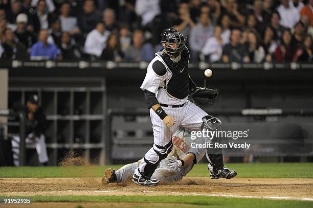 Pierzynski of the Chicago White Sox can't catch the ball as Nick Punto of the Minnesota Twins scores in the sixth inning on September 21, 2009 at...