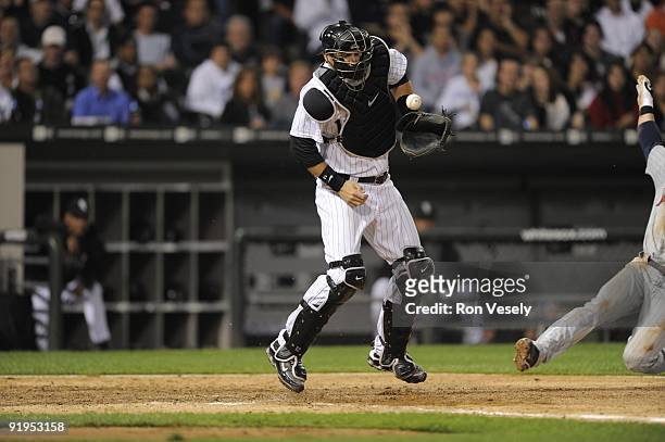 Pierzynski of the Chicago White Sox can't catch the ball as Nick Punto of the Minnesota Twins scores in the sixth inning on September 21, 2009 at...