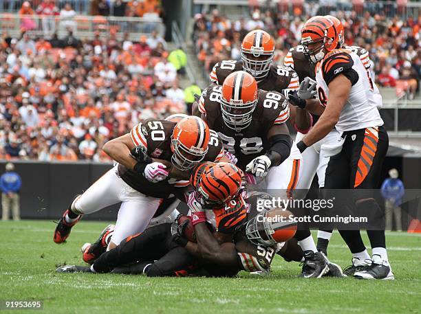 Bernard Scott of the Cincinnati Bengals is tackled by D'Qwell Jackson and Eric Barton of the Cleveland Browns at Cleveland Browns Stadium on October...