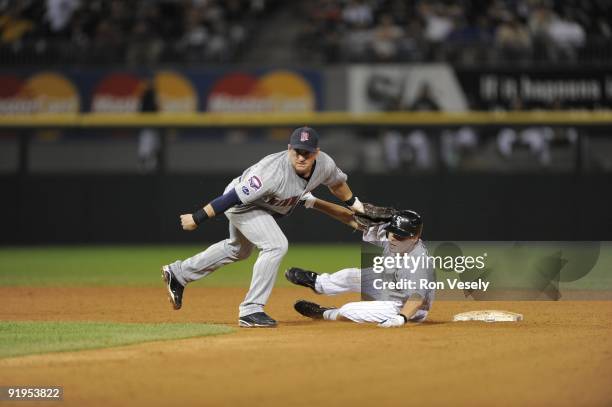 Nick Punto of the Minnesota Twins turns a double play over a sliding Chris Getz of the Chicago White Sox on September 21, 2009 at U.S. Cellular Field...