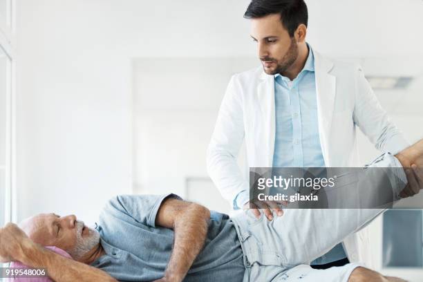 senior man having medical exam. - hip body part stock pictures, royalty-free photos & images