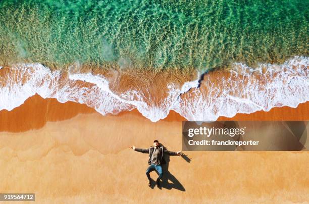 man lying down on the beach - bondi beach sand stock pictures, royalty-free photos & images