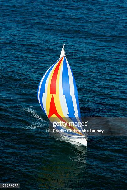 aerial view of a sailing yacht with a colorful spinnaker cruising in pittwater on the north shore fr - pittwater stock pictures, royalty-free photos & images