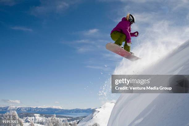 a female snowboarder doing a 540 in the backcountry on a sunny day in, california. - freestyle snowboarding stock pictures, royalty-free photos & images
