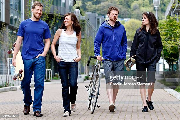 a group of friends having fun with a bike and a skateboard in the city. - newfriendship stock pictures, royalty-free photos & images