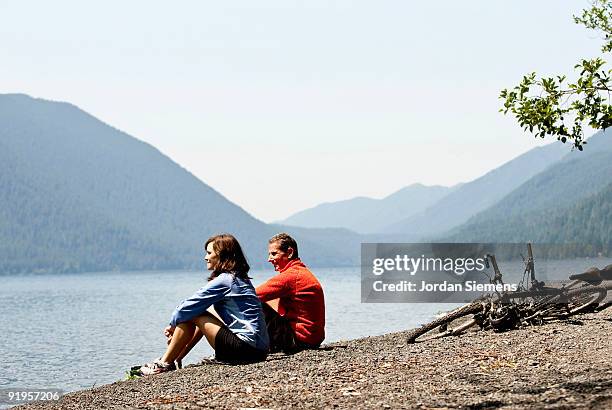 mountain bikers enjoying views of the lake and hillsides covered in trees. - lago crescent fotografías e imágenes de stock