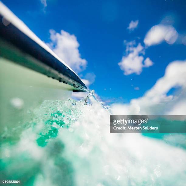 turquoise water splashing from motorboat bow in motion - merten snijders stock-fotos und bilder