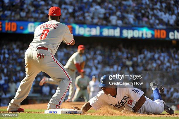 Juan Pierre of the Los Angeles Dodgers dives back to first base on a pick up attempts by Ryan Howad and pitcher Chan Ho Park of the Philadelphia...