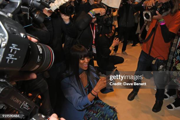Naomi Campbell wearing Burberry takes photos backstage at the Burberry February 2018 show during London Fashion Week at Dimco Buildings on February...