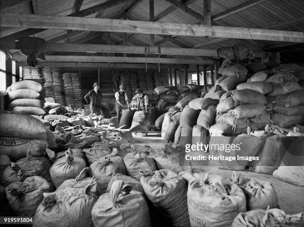 Goods shed, Ulverston Goods Station, Cumbria, 1927. Men moving sacks of dairy meal in a depot used by the Furness and South Cumberland Supply...