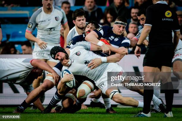 Toulouse's French flanker Francois Cros is tackled by Agen's players during the French Top 14 rugby union match between SU Agen and Toulouse at The...