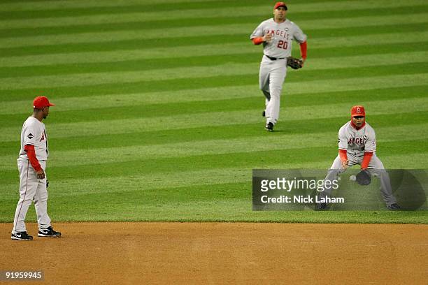 Erick Aybar of the Los Angeles Angels of Anaheim lets a fly ball drop while Juan Rivera and Chone Figgins look on in the first inning of Game One of...