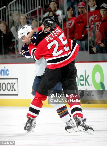 Eric Boulton of Atlanta Thrashers is punched in the face by Andrew Peters of the New Jersey Devils during there game at the Prudential Center on...
