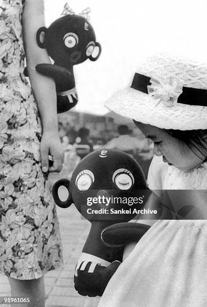 Girl holds a "Dakko-chan" doll in the 1960s in Japan.