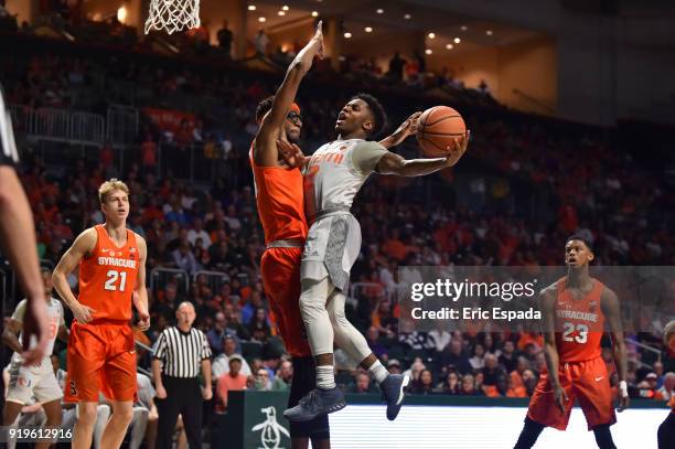 Chris Lykes of the Miami Hurricanes takes a shot while being defended by Paschal Chukwu of the Syracuse Orange during the second half of the game at...