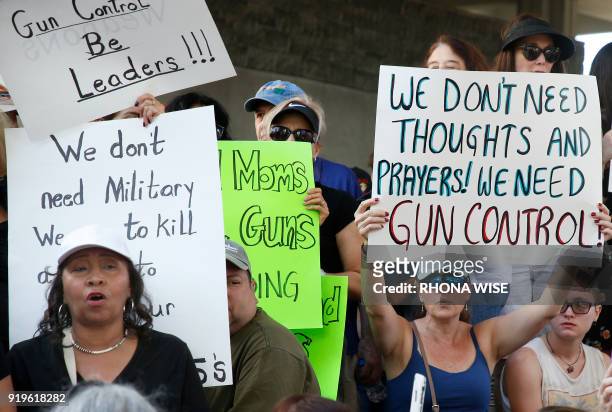 Protesters hold signs at a rally for gun control at the Broward County Federal Courthouse in Fort Lauderdale, Florida on February 17, 2018. Seventeen...